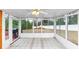 Bright sunroom with tiled floors, ceiling fan and large windows offering views of the backyard at 5705 Mountain Cres, Stone Mountain, GA 30087