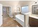 Bathroom featuring a soaking tub, tile surround, and a vanity with ample counter space at 2100 Trinity Mill Dr, Dacula, GA 30019