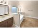 Bright bathroom featuring a soaking tub and vanity with granite countertop at 2100 Trinity Mill Dr, Dacula, GA 30019