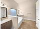 Bright bathroom featuring a soaking tub, tile surround, and a vanity with ample counter space at 2100 Trinity Mill Dr, Dacula, GA 30019