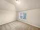 Bedroom features carpeted flooring, a window for natural light, and neutral walls at 2100 Trinity Mill Dr, Dacula, GA 30019