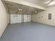 Spacious two-car garage with gray epoxy flooring and two garage door openers at 2100 Trinity Mill Dr, Dacula, GA 30019