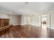 Open living room featuring a brick fireplace, dark hardwood floors, and access to other rooms at 3454 Ashwood Ln, Atlanta, GA 30341