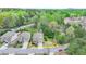 Aerial view showcasing property lines of a brick home in a tree-filled suburban neighborhood near the highway at 6845 Rocking Horse Ln, Cumming, GA 30040
