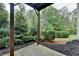 Backyard patio area surrounded by lush greenery, offering a private and serene outdoor space at 6845 Rocking Horse Ln, Cumming, GA 30040