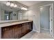 Bathroom featuring double vanity, granite countertop, large mirror, and stylish lighting at 6845 Rocking Horse Ln, Cumming, GA 30040