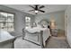 Bedroom with beautiful bed, two windows providing natural light, ceiling fan and carpet at 6845 Rocking Horse Ln, Cumming, GA 30040