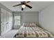 Serene bedroom featuring a queen-size bed with soft carpet, ceiling fan, and a double door closet at 6845 Rocking Horse Ln, Cumming, GA 30040