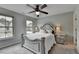 Bedroom with beautiful bed, two windows providing natural light, ceiling fan and carpet at 6845 Rocking Horse Ln, Cumming, GA 30040