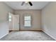 Bright bedroom with neutral walls and carpet, ceiling fan, and a window at 6845 Rocking Horse Ln, Cumming, GA 30040