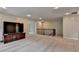 Open bonus room with plush carpeting, recessed lighting, tv console, and stairway at 6845 Rocking Horse Ln, Cumming, GA 30040
