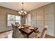 Dining room with hardwood floors, modern lighting, and decorative wall paneling at 6845 Rocking Horse Ln, Cumming, GA 30040