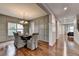 Elegant dining room with hardwood floors, decorative wall paneling, and modern chandelier at 6845 Rocking Horse Ln, Cumming, GA 30040