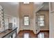 Light-filled foyer with hardwood floors and decorative wall paneling detail at 6845 Rocking Horse Ln, Cumming, GA 30040