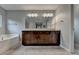 Bathroom featuring double vanity, a soaking tub, and a large mirror at 6845 Rocking Horse Ln, Cumming, GA 30040