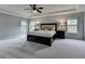 Main bedroom with tray ceiling, carpet, two bedside tables and a large window at 6845 Rocking Horse Ln, Cumming, GA 30040