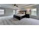 Spacious main bedroom with a ceiling fan, tray ceiling, neutral paint, and multiple windows at 6845 Rocking Horse Ln, Cumming, GA 30040