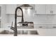 Close-up of a stainless steel sink and gooseneck faucet against a white backsplash and stainless steel range at 118 Via Roma, Woodstock, GA 30188