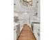 Spacious kitchen with white cabinets, stainless appliances, hardwood floor and curved staircase at 118 Via Roma, Woodstock, GA 30188