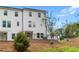 The white home has a spacious terrace, black metal fence, green lawn and newly planted tree in its backyard at 125 Werner Brook Sw Way, Atlanta, GA 30354