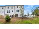 A well maintained backyard of a white, two-story home has a terrace, black metal fence, and an attractive lawn at 125 Werner Brook Sw Way, Atlanta, GA 30354
