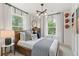 Cozy bedroom featuring a leather bed frame, decorative pillows, and natural light from the large window at 125 Werner Brook Sw Way, Atlanta, GA 30354