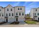 Three-story townhome with attached garage, a covered entry, and a well-maintained lawn at 125 Werner Brook Sw Way, Atlanta, GA 30354
