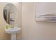 Stylish half bathroom featuring a modern pedestal sink, oval mirror, and elegant wall art at 125 Werner Brook Sw Way, Atlanta, GA 30354