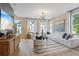 Open-concept living room with large windows, modern chandelier, and a comfortable white sectional sofa at 125 Werner Brook Sw Way, Atlanta, GA 30354