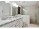 Bathroom featuring dual sinks, granite countertops, walk-in shower, and bright light at 1916 Cannon St, Decatur, GA 30032