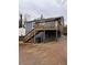 Backyard featuring a wooden deck with staircase, painted foundation, and driveway at 197 Upshaw Sw St, Atlanta, GA 30315