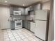Bright kitchen featuring white appliances, gray cabinets, subway tile backsplash, and tile flooring at 197 Upshaw Sw St, Atlanta, GA 30315