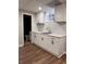 Clean basement kitchenette featuring white cabinetry, modern fixtures, and laminate flooring at 197 Upshaw Sw St, Atlanta, GA 30315