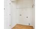 Compact laundry room with white walls, wood-look floor, and a wire shelf for storage at 103 Timber Ridge Dr, Cartersville, GA 30121