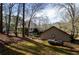 Backyard view of a tan two story home with a propane tank and a wooded landscape at 150 Karina Pl, Canton, GA 30115