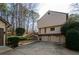 Back of house view of the exterior of a tan two story home with a stone water feature and three car garage at 150 Karina Pl, Canton, GA 30115