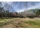 Expansive front yard featuring a mix of trees and a well-maintained lawn, creating an inviting approach to the property at 150 Karina Pl, Canton, GA 30115