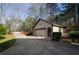 View of the driveway leading to the three-car garage with lawn and landscaping at 150 Karina Pl, Canton, GA 30115