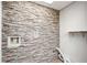 Laundry room featuring a stone wall and storage shelf, providing a stylish utility space at 150 Karina Pl, Canton, GA 30115