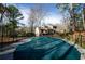 Fenced-in pool with cover in place surrounded by a wooded area and a view of the house in the background at 150 Karina Pl, Canton, GA 30115