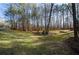 Manicured front yard with a circle of bushes and mature trees at 150 Karina Pl, Canton, GA 30115