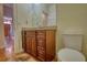 Elegant half bath with a granite countertop, wood cabinet, and wood floors at 5770 Wyndemere Ln, Stone Mountain, GA 30087