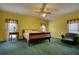 Spacious bedroom features bright yellow walls, green carpet, and matching wood furnishings at 5770 Wyndemere Ln, Stone Mountain, GA 30087
