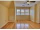 Bedroom featuring hardwood floors, light-yellow painted walls, and a large window at 5770 Wyndemere Ln, Stone Mountain, GA 30087