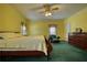 Bedroom featuring bright yellow walls, green carpet, wood dresser and a dark green chair at 5770 Wyndemere Ln, Stone Mountain, GA 30087