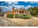 Side view showcasing the home's brick architecture, a large chimney, attached garage and a well-kept landscape at 5770 Wyndemere Ln, Stone Mountain, GA 30087
