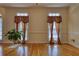 Bright living room featuring hardwood floors and large windows with decorative curtains at 5770 Wyndemere Ln, Stone Mountain, GA 30087