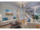 Comfortable living room featuring hardwood floors, a staircase, and neutral-toned furniture with blue pillows at 5770 Wyndemere Ln, Stone Mountain, GA 30087
