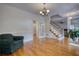 Living room with hardwood floors, staircase with white railing, and ample natural light from the windows at 5770 Wyndemere Ln, Stone Mountain, GA 30087