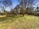 Expansive backyard featuring a wooden deck and mature trees at 6296 Flamingo Way, Morrow, GA 30260